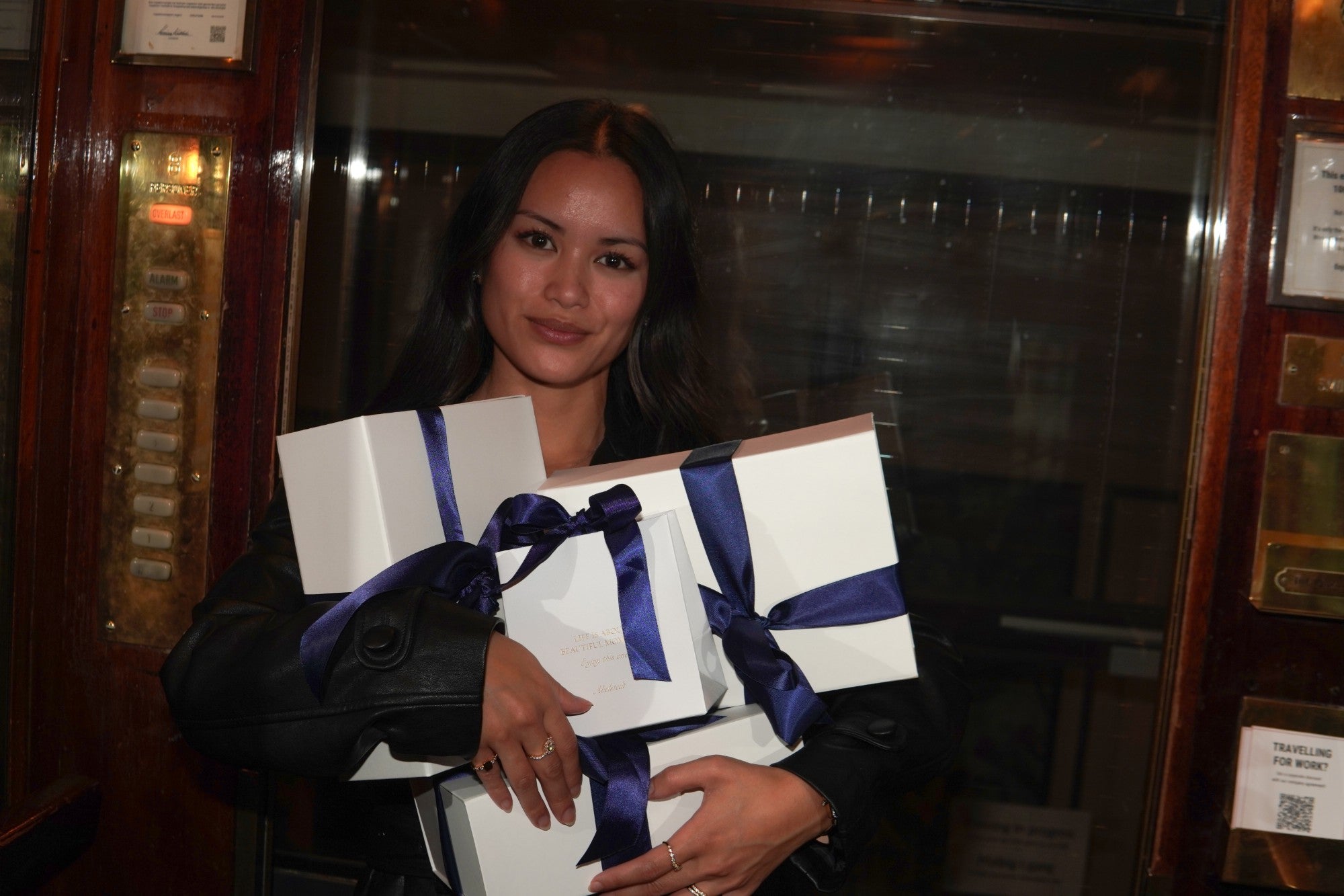 Woman with her arms full of Abelstedt gift boxes with navy bows